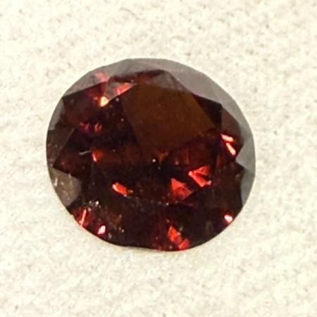 Zirkon med dyp rød farge og sterk refleksjon. Denne måler ø 9,5 mm og veier 3,9 ct 